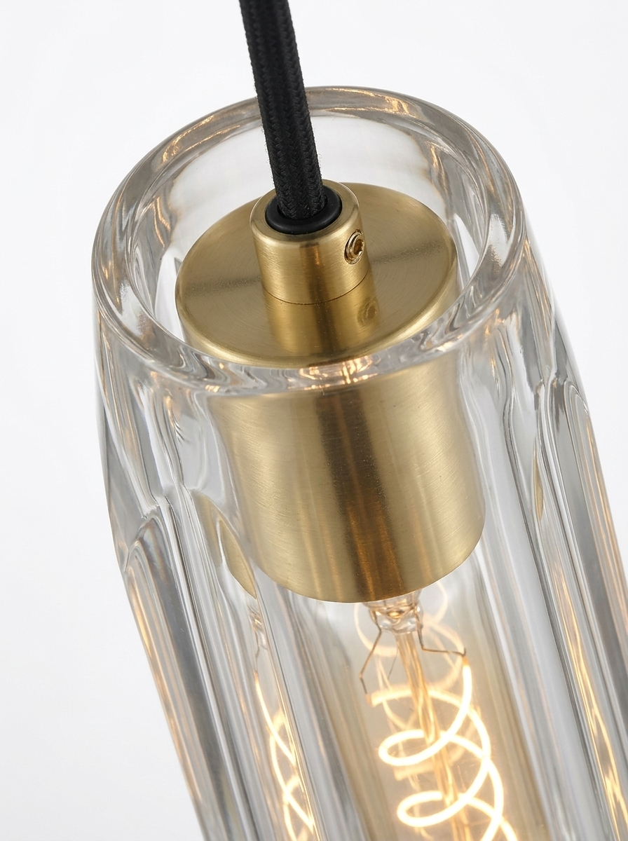 Close-up of the polished brass cap and socket where the cord meets the crystal