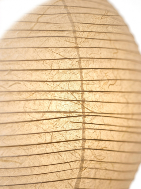 Macro of the ribbed washi rice-paper shade glowing warm