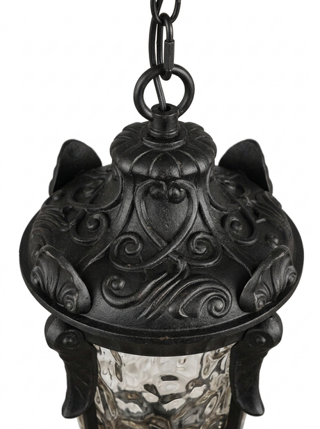 Close-up of the ornate cast-metal scrollwork crown of the lantern
