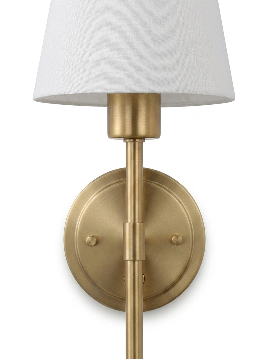 Close-up of the brushed-brass hardwired sconce stem, backplate and empire shade