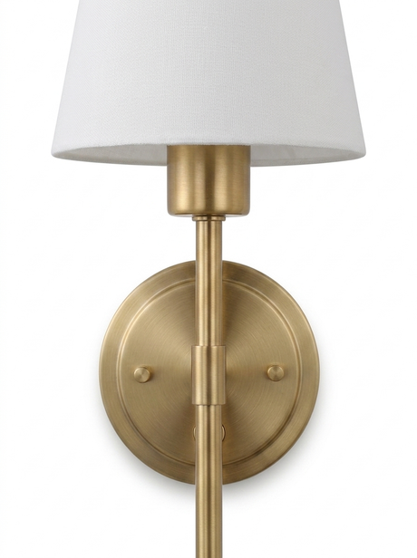 Close-up of the brushed-brass hardwired sconce stem, backplate and empire shade