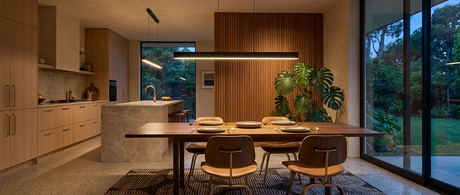 Onyx linear pendant glowing over a walnut dining table in a mid-century modern kitchen lifestyle