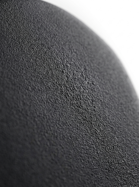 Macro of the matte charcoal-black powder-coat texture