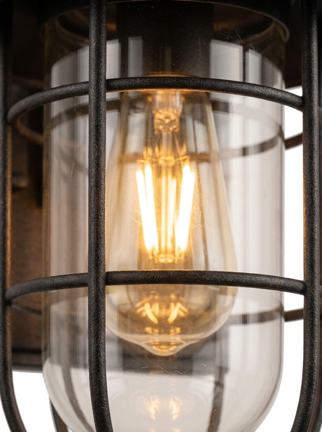 Close-up of the black metal cage frame wrapping the clear glass cylinder