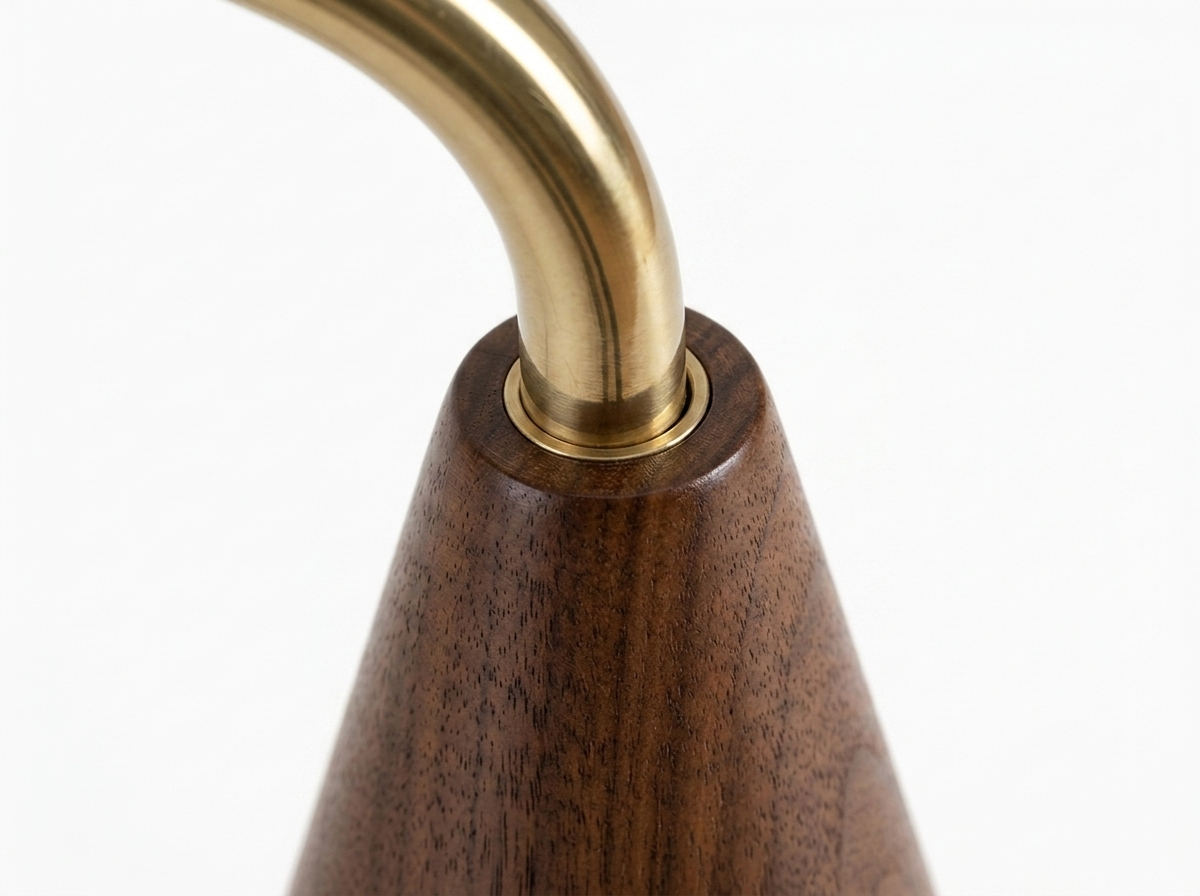 Cyra brass pole to walnut base join close-up