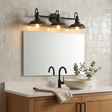 Doria 3-light vanity light over a mirror in a warm farmhouse bathroom