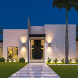 Ilse concrete up-down wall lights, pair on a modern white home at dusk