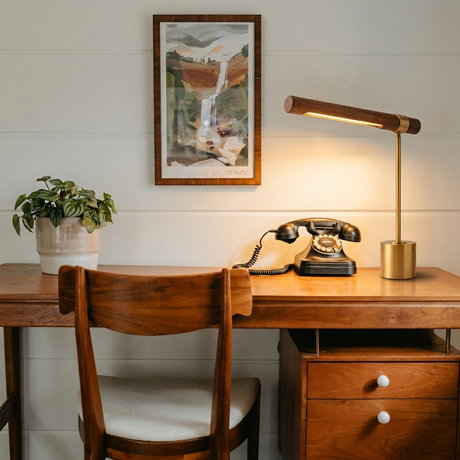 Ivo walnut-and-brass desk lamp on a mid-century desk with vintage phone and framed art