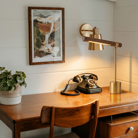 Ivo walnut-and-brass desk lamp on a warm mid-century desk with framed art