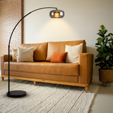Dara arc floor lamp over a tan leather sofa in a mid-century living room