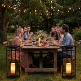 Ferro lanterns flanking a farmhouse backyard dinner party — lifestyle