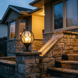 Lune globe pillar lantern on a stone pier by the front steps of a home at dusk