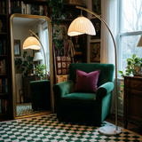 Arcadia arc floor lamp over an emerald velvet armchair with brass mirror and green checkerboard rug