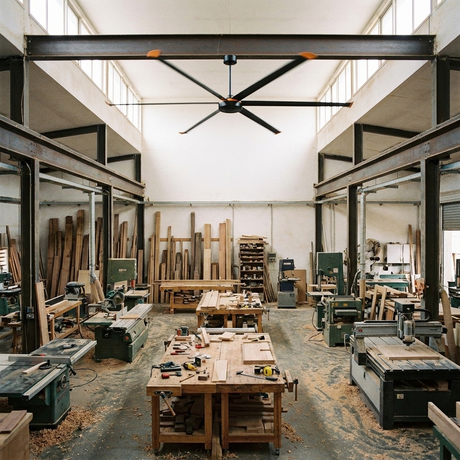 Isaac HVLS industrial ceiling fan spanning a woodworking and fabrication workshop
