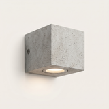 Ilse concrete outdoor wall light lit warm on a soft off-white studio background