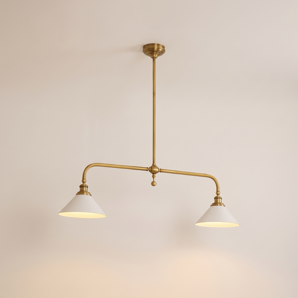 Thetford linear brass pendant lit warm on a soft off-white studio background