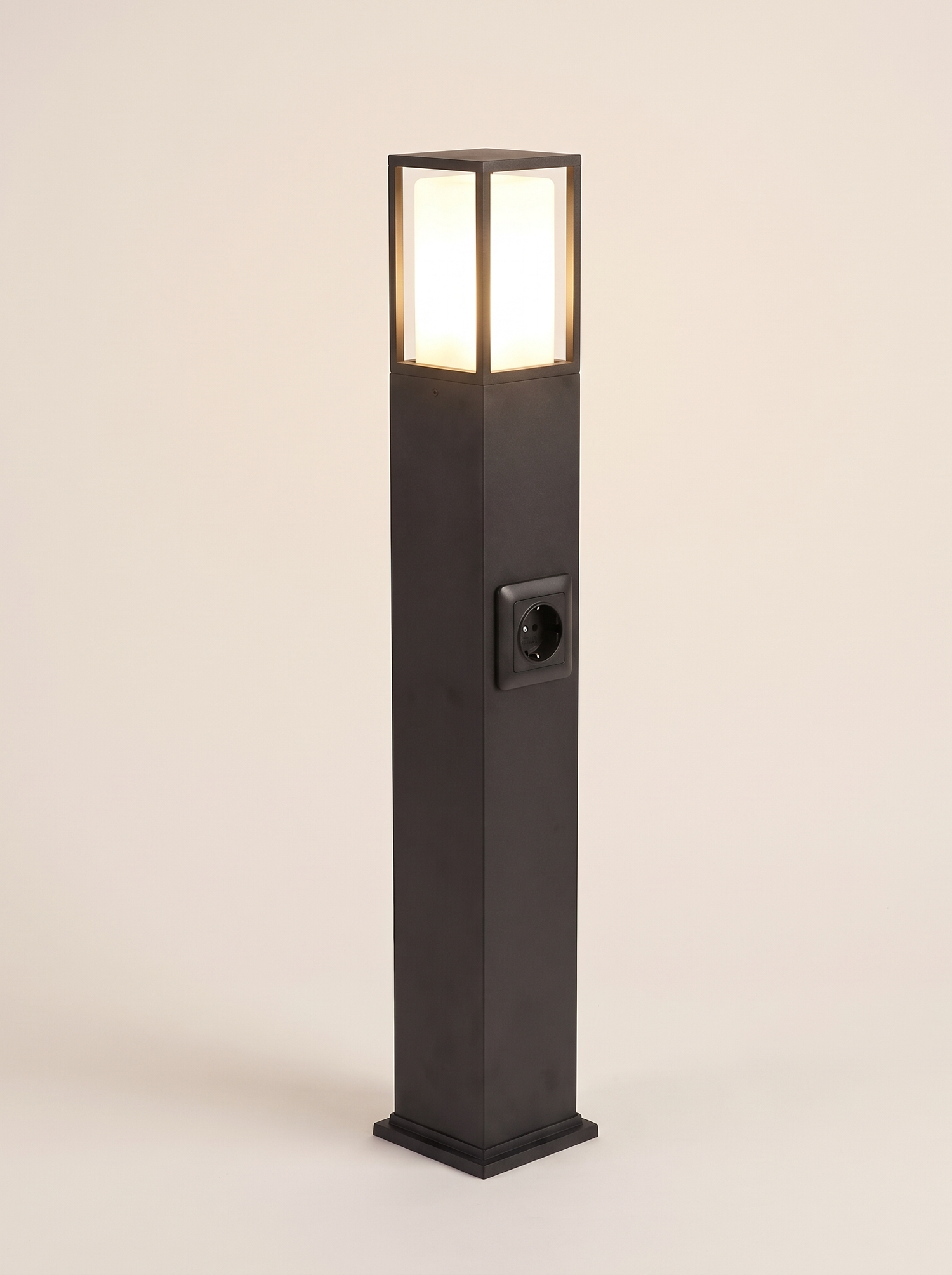 Cairn bollard path light lit warm on a soft off-white studio background