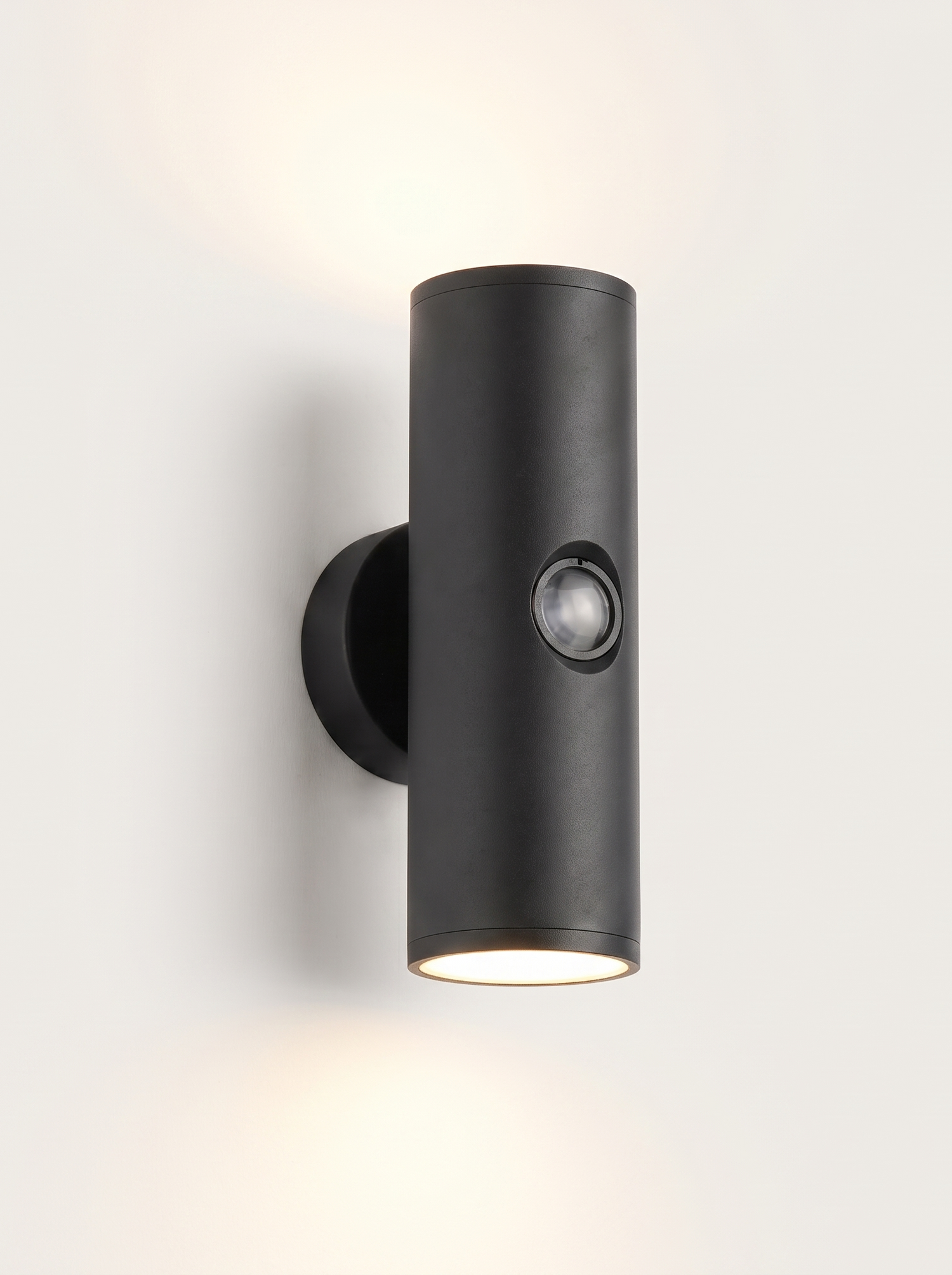 Vega up-and-down outdoor wall light lit warm on a soft off-white studio background