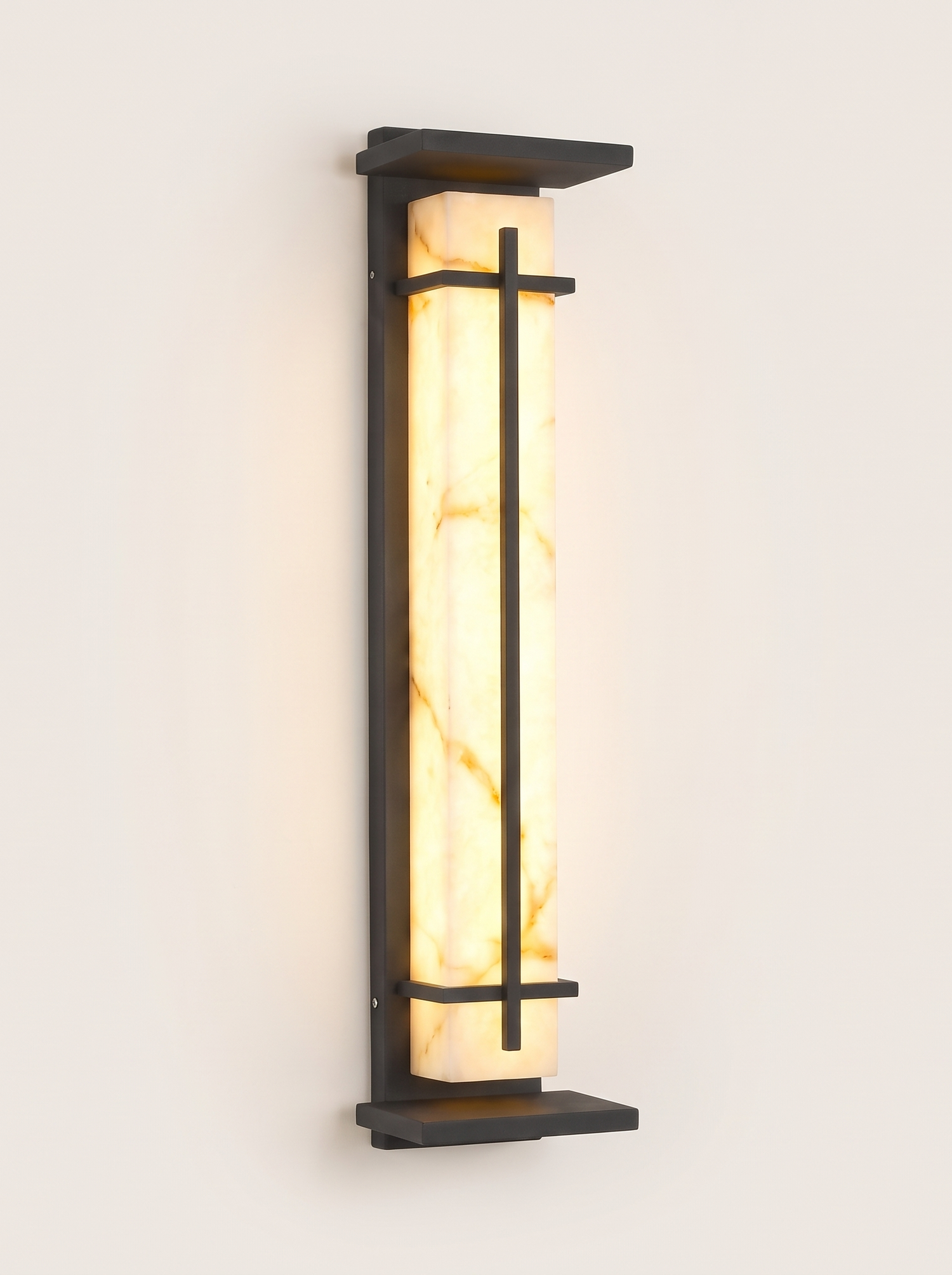 Luminara marble-panel outdoor wall sconce lit warm on a soft off-white studio background