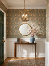 Lifestyle: soft gold Kiel lantern pendant in an entry hall with floral wallpaper, shown to scale above a walnut console