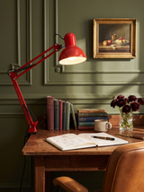 Lifestyle: Otis architect clamp lamp in red on an antique writing desk against green panelling