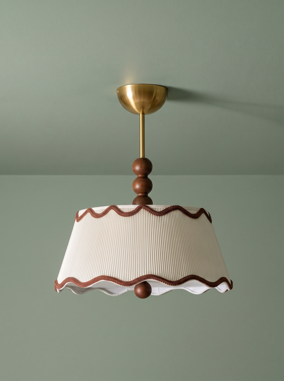 Odette flush mount in cream and walnut on a sage green backdrop