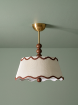 Odette flush mount in cream and walnut on a sage green backdrop