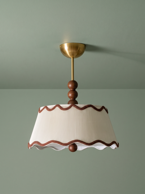 Odette flush mount in cream and walnut on a sage green backdrop