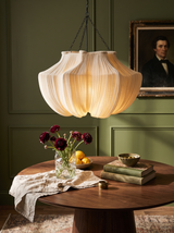 Lifestyle: Nessa fabric lantern chandelier glowing over a walnut dining table in an olive room