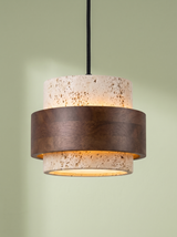 Rune travertine and walnut pendant light glowing on a pistachio green backdrop