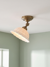 Colette ceiling light in antique brass and white porcelain on a sage backdrop