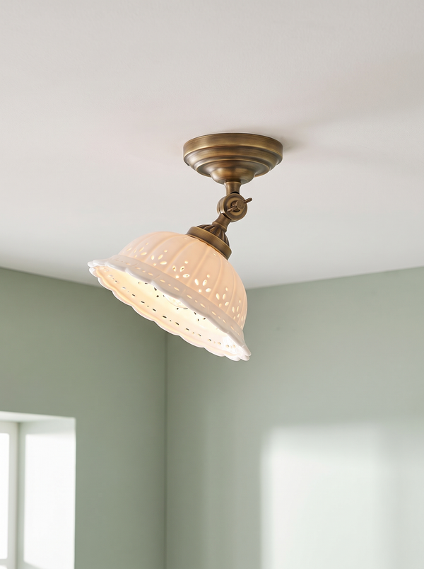 Colette ceiling light in antique brass and white porcelain on a sage backdrop