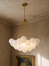 Perle chandelier in gold with frosted glass globes in a plaster-moulded corner