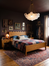 Lifestyle: Perle globe chandelier above a bed in a plum-brown bedroom
