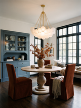 Lifestyle: Perle chandelier over a round oak table beside a slate-blue china cabinet