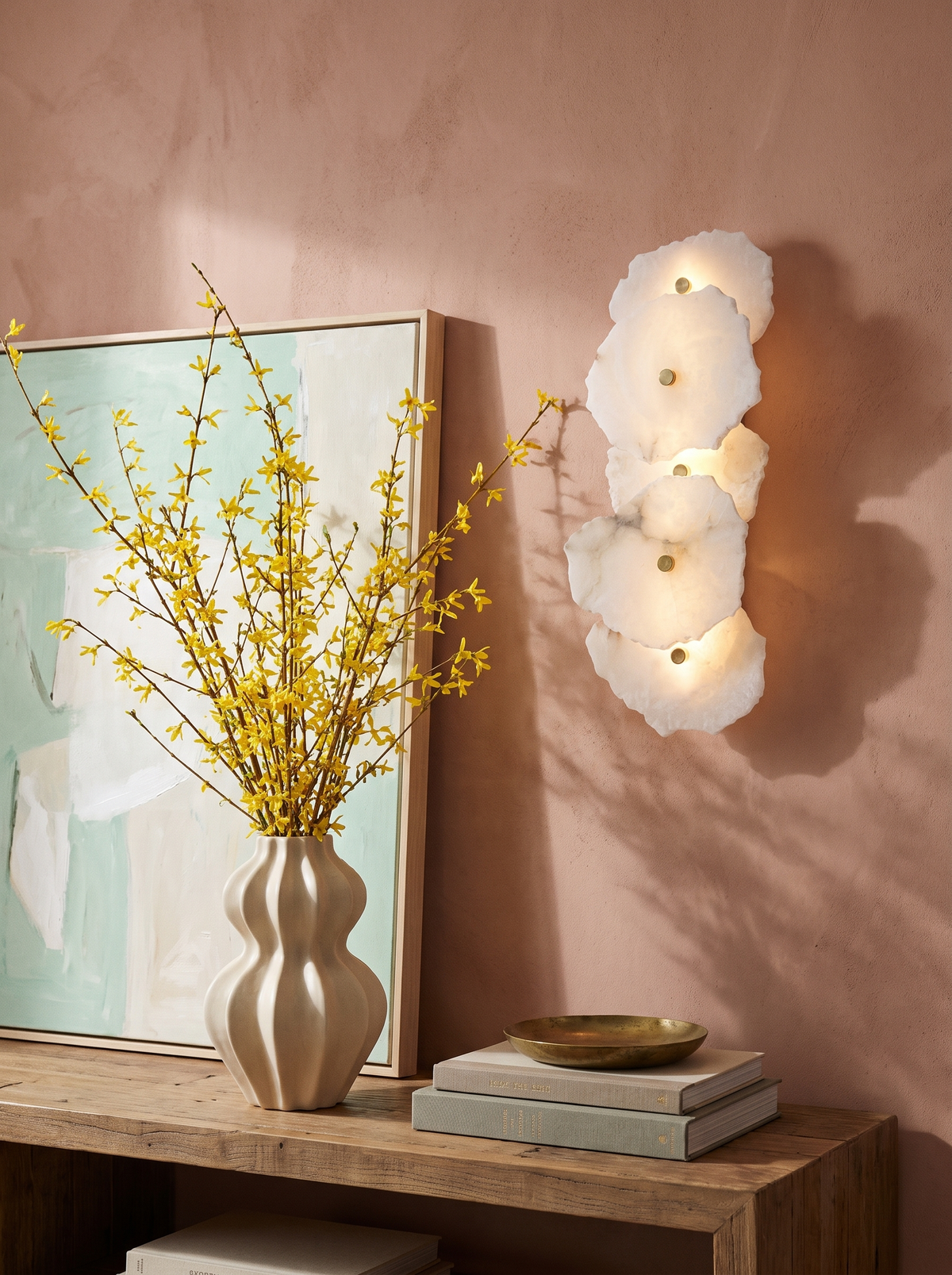 Lifestyle: Seren alabaster sconce above a console on a dusty-pink plaster wall