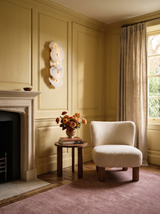 Lifestyle: Seren alabaster sconce beside a limestone fireplace in a butter-yellow room, showing its size