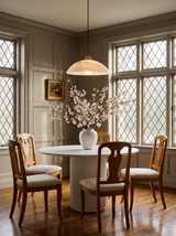 Lifestyle: Cala alabaster pendant over a fluted table in a greige panelled dining room
