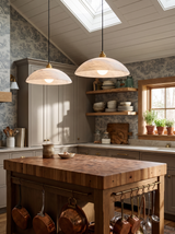 Lifestyle: two Cala alabaster pendants over a butcher-block island in a toile kitchen, showing their size
