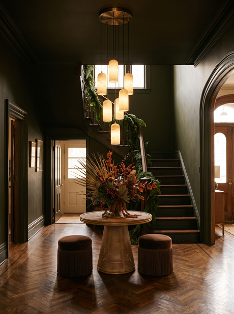 Lifestyle: a seven-pendant Sola alabaster cluster in an olive-black stair hall