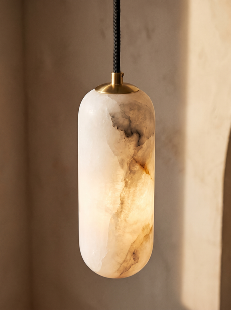 Lifestyle: close-up of Sola's veined alabaster cylinder, brass cap and braided cord