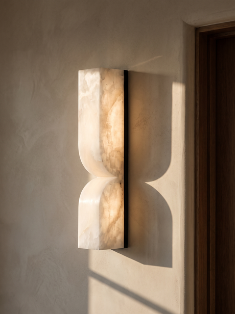 Aurelie carved alabaster wall sconce in black and white on a greige plaster wall