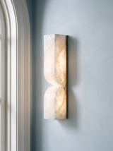Aurelie carved alabaster wall sconce in nickel and white on a powder-blue plaster wall