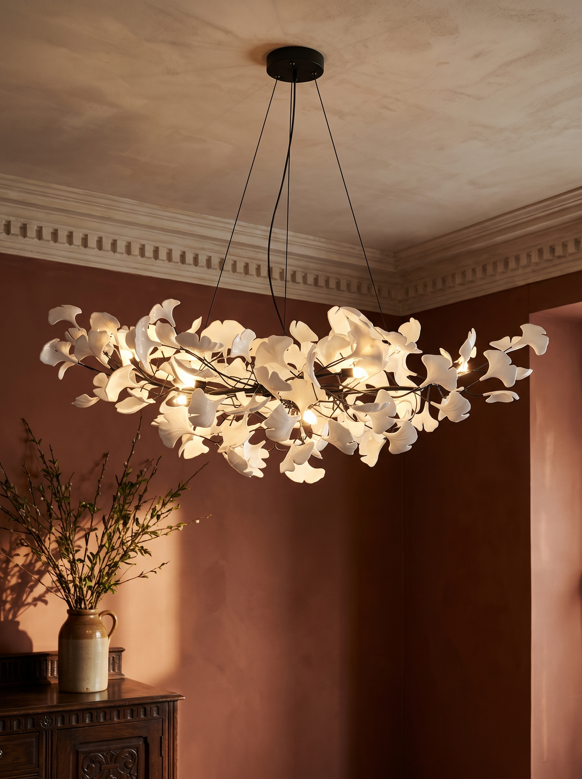 Ginevra porcelain ginkgo leaf chandelier in black against terracotta plaster