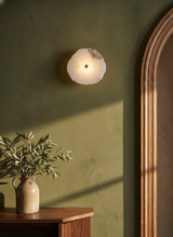 Seren single-disc alabaster wall sconce on an olive plaster wall