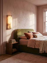 Lifestyle: Clio ribbed alabaster sconce beside an olive velvet bed in a rose plaster bedroom