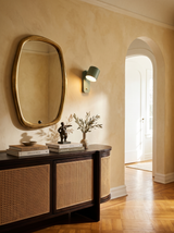 Lifestyle: Tate swivel wall lamp beside a brass mirror in a plaster entry, showing its size