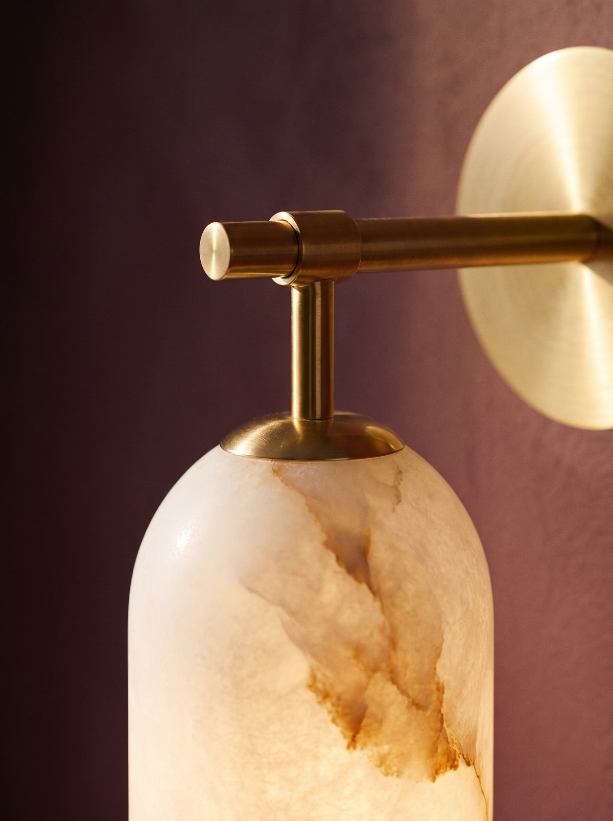 Lifestyle: close-up of Pilar's brass arm and glowing alabaster shade