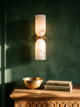 Nyx up-and-down alabaster wall sconce in copper on a forest-green plaster wall
