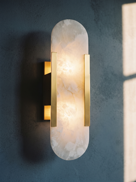 Lifestyle: close-up of Romy's veined alabaster shade and brass bars, lit